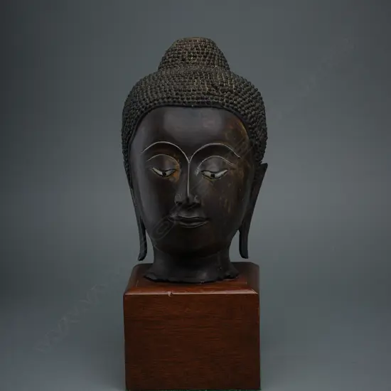 Thai bronze Buddha head fragment, mounted on wooden stand, H.320mm, some traces of gilding